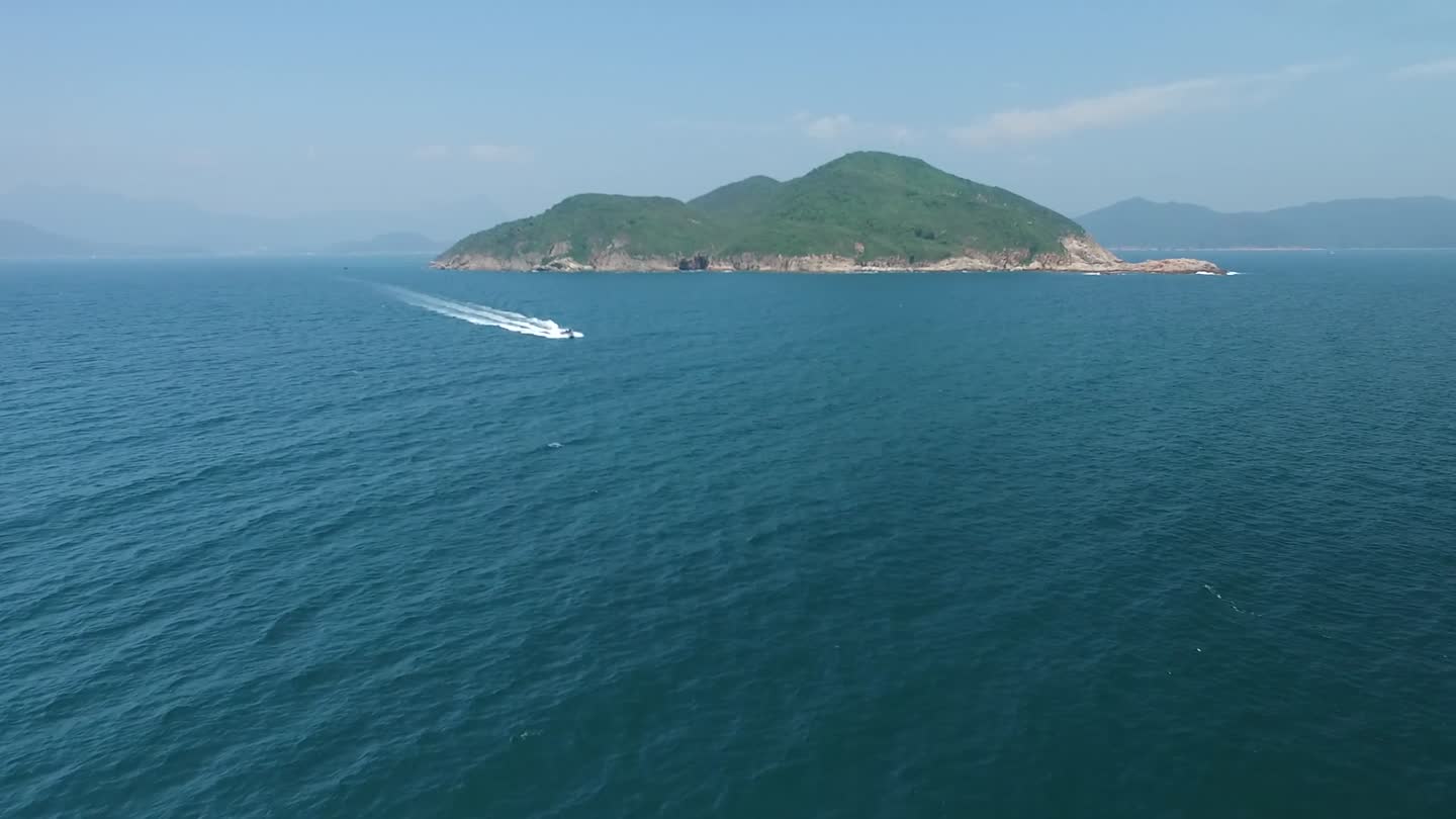 A boat leaves a white trail across deep blue water